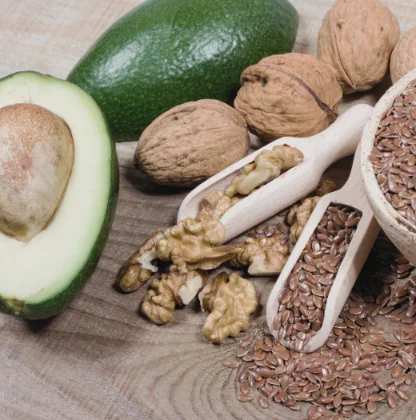 Auswahl an Omega-3-haltigen Lebensmitteln wie Nüssen, Leinsamen und Avocado für eine gesunde Haut.
